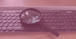 Tastatur auf der eine Lupe liegt - soll die Suchintention verdeutlichen
